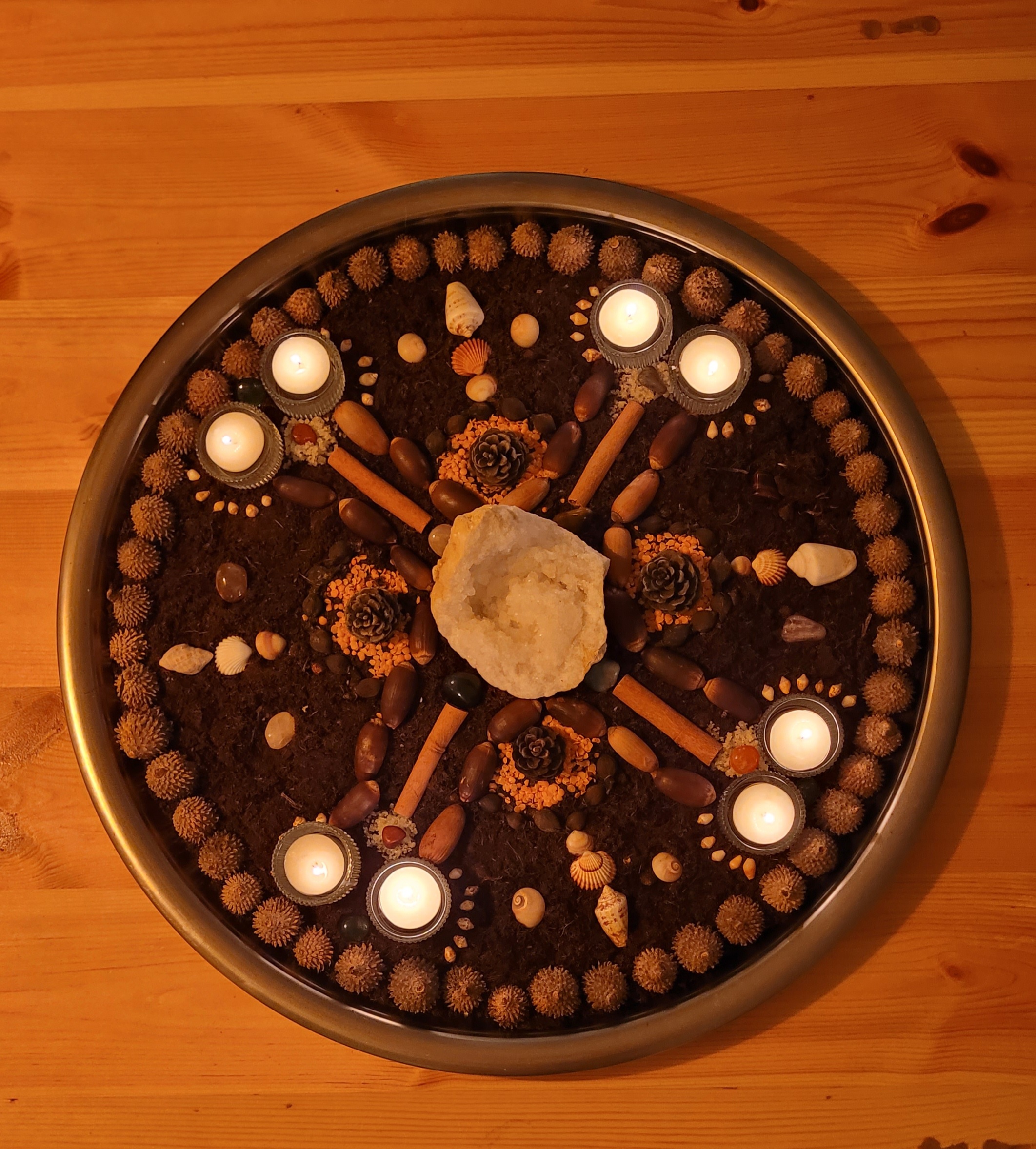 Earth mandala with crystals, seeds, and candlelight